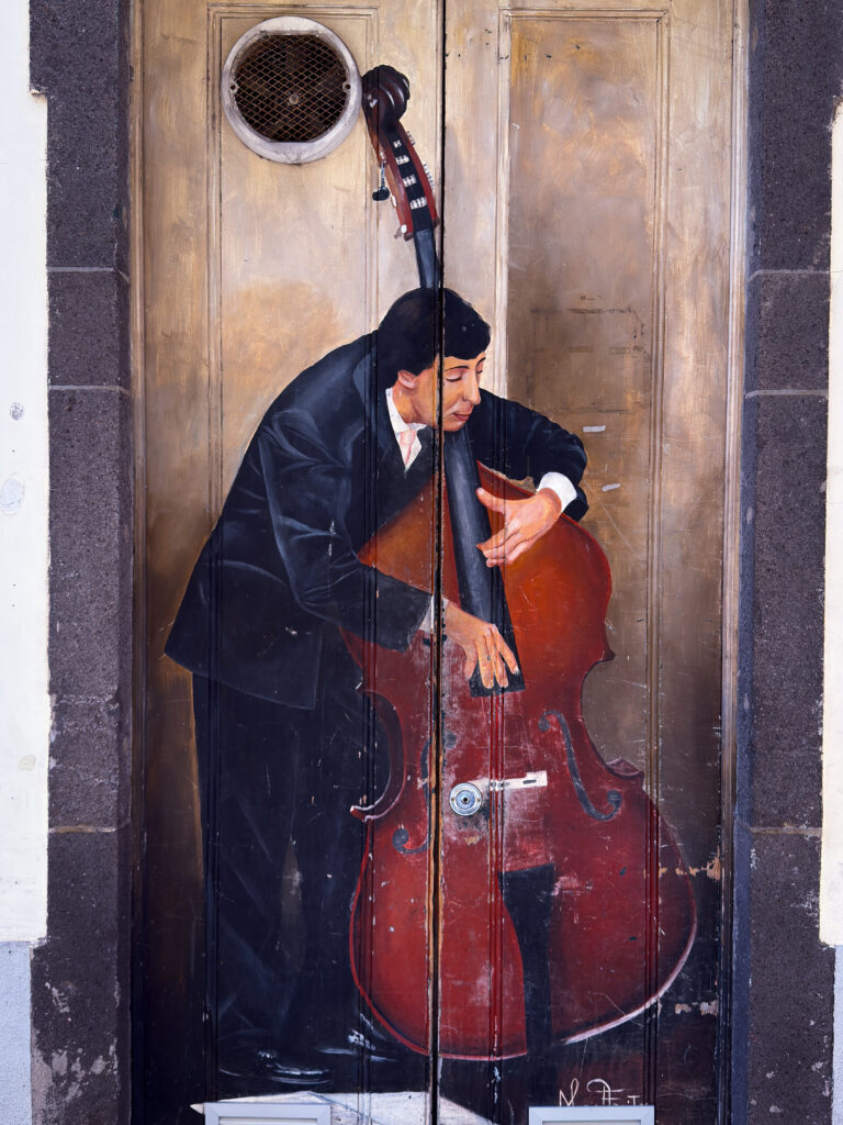 Cello-Spieler in Funchal, gemalt auf eine Tür