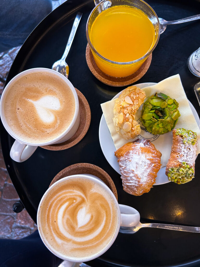 Zwei Cappuccino, ein frisch gestresster Orangensaft und griechisches Gebäck