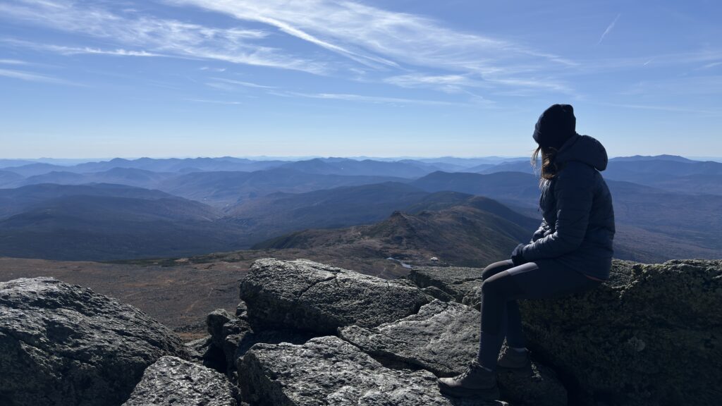 Vanessa blickt vom Mount Washington auf die Ebene.
