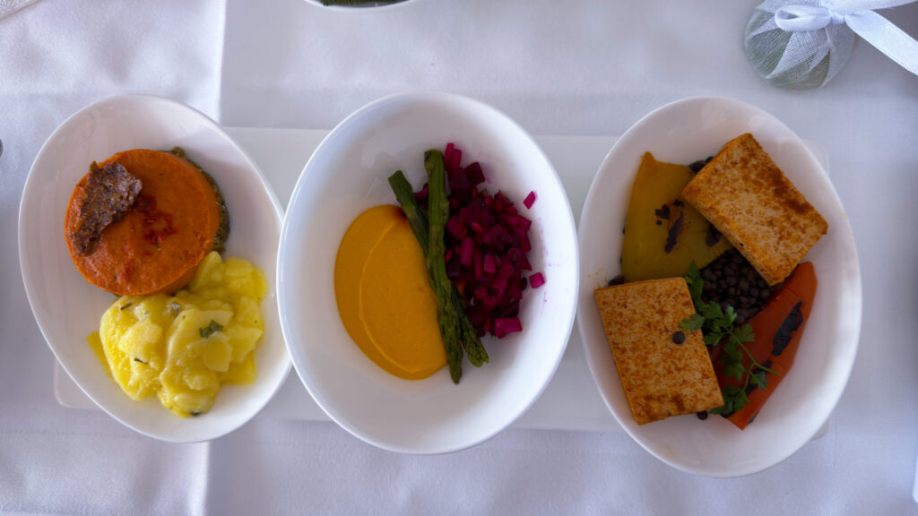 Drei Teller mit veganen Vorspeisen im Flugzeug